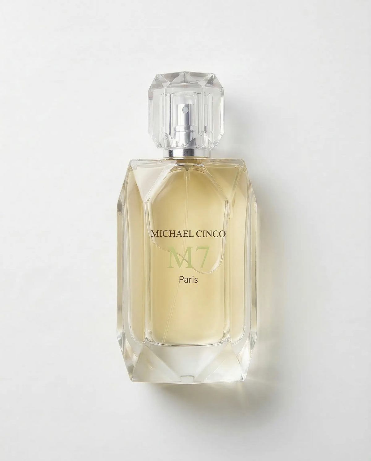 Michael Cinco M7 Paris perfume bottle with a faceted clear glass cap and a pale yellow liquid inside, set against a plain light gray background.