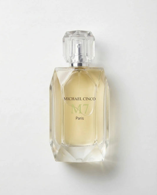 Michael Cinco M7 Paris perfume bottle with a faceted clear glass cap and a pale yellow liquid inside, set against a plain light gray background.