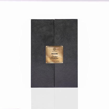 A black, rectangular, textured perfume box stands upright on a reflective surface, featuring a gold label with "Massimo Eau de Parfum - Christian Provenzano"—ideal for lovers of spicy amber or leather fragrances by Christian Provenzano.