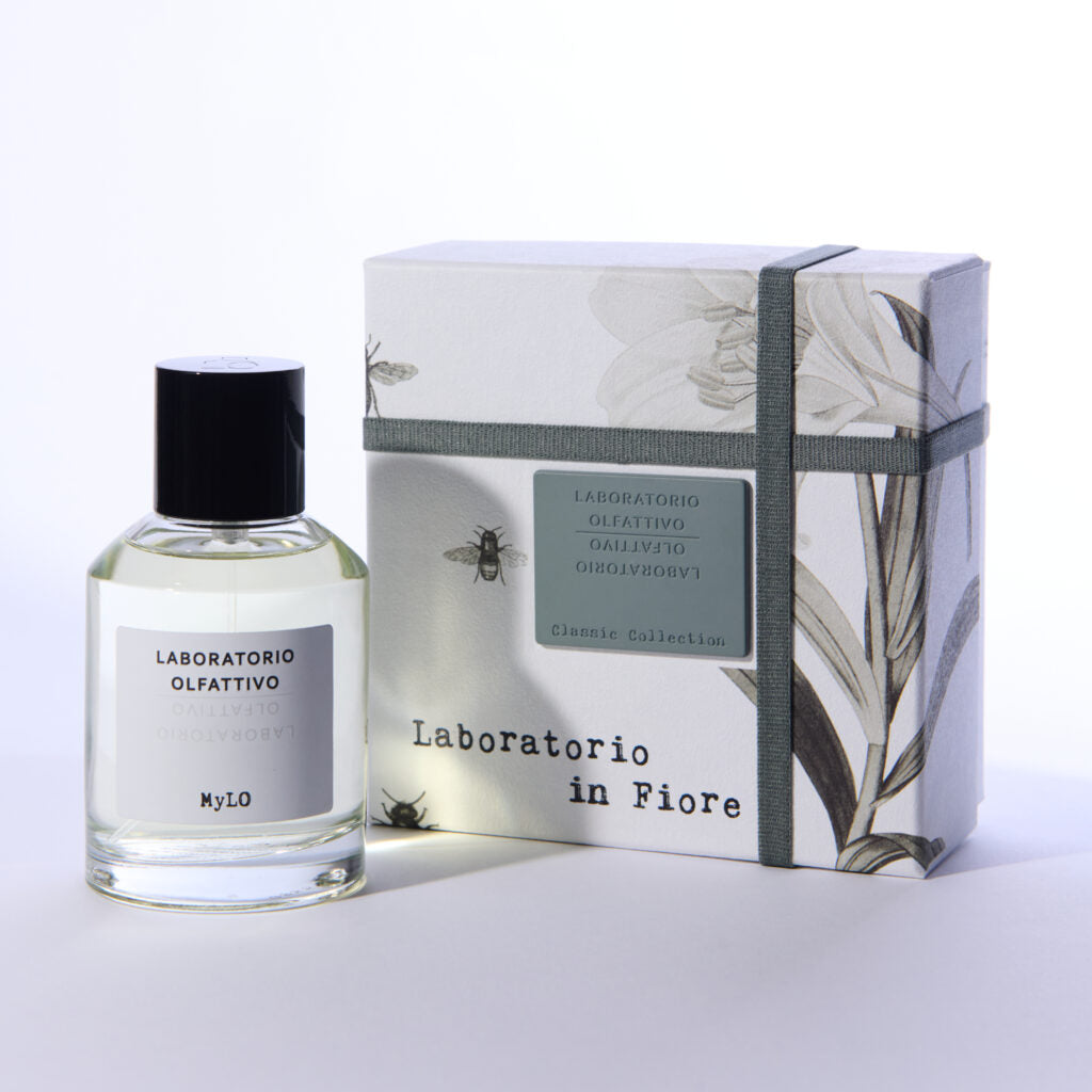 A bottle of MyLO by Laboratorio Olfattivo stands beside its floral-patterned box, both branded Laboratorio Olfattivo, exuding an elegant floral scent against a white backdrop.