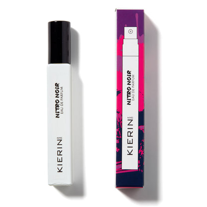 A white rectangular bottle of Kierin Nitro Noir Eau de Parfum stands beside its vibrant purple and pink box, reflecting the bold spirit and luxe allure of this signature scent from Kierin.