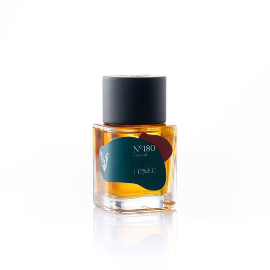 A square glass bottle of N80 Parfum by Fennec with amber liquid, green label featuring abstract red and yellow shapes, black cylindrical cap, and white background.