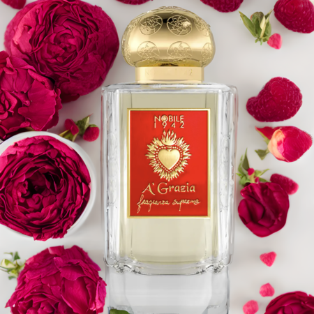 The A' GRAZIA "SAN GENNARO, TAKE CARE OF IT!" Eau de Parfum by Nobile 1942 features a gold-capped bottle amidst red roses and raspberries, capturing the essence of Neapolitan culture and the legend of San Gennaro.