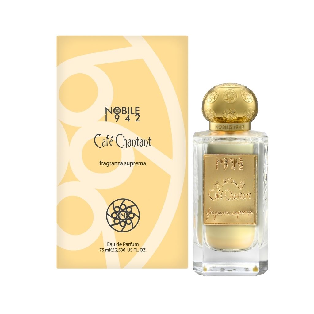 A bottle of Nobile 1942 CAFE CHANTANT Eau de Parfum with a gold cap and gold label is displayed beside its light yellow, gold-accented box adorned with decorative designs.