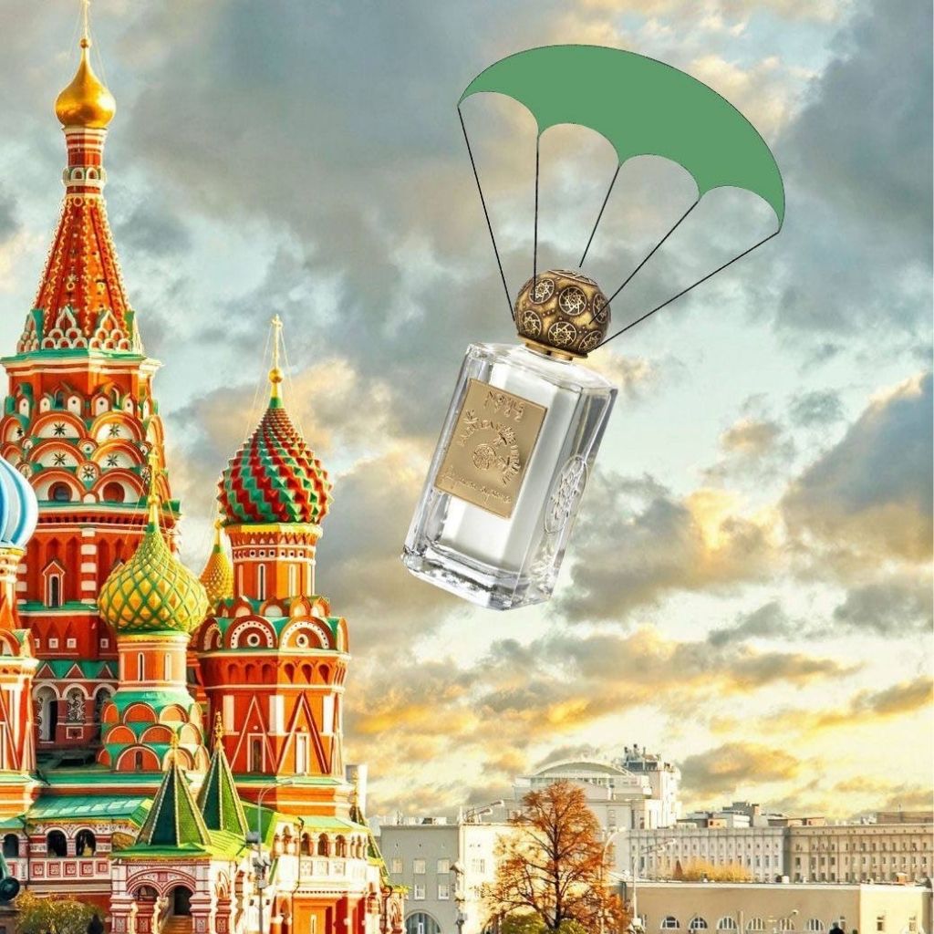 A green-parachuted bottle of LA DANZA DELLE LIBELLULE EDP by Nobile 1942 drifts near Saint Basil's Cathedral in Moscow, reflecting the fragrance’s gourmand spirit against a dramatic sunset sky.