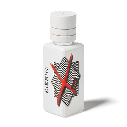 A white bottle of ScentXOne Eau de Parfum by Kierin features a geometric black-and-white pattern and a bold red X on the front. This luxury perfume has a sleek design with a matching cap and casts a soft shadow.