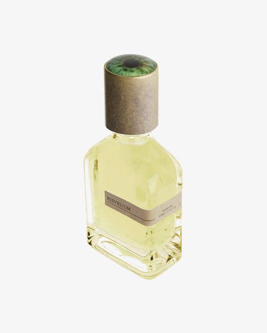 Risvelium Eau de Parfum by Fragrapedia Haus: a glass bottle with pale yellow liquid, labeled RISVELUM, topped with a unique cap featuring a green eye image, set against white—a truly ethereal scent from Orto Parisi.