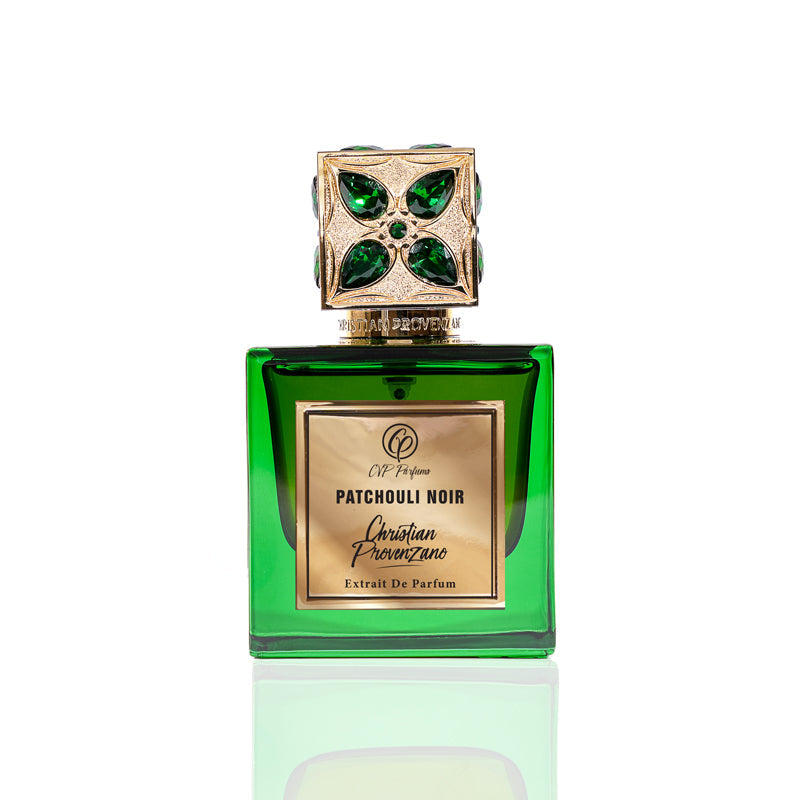 A green glass bottle of Patchouli Noir Eau de Parfum by Christian Provenzano, featuring a gold and green jeweled cap, is displayed on a white background.