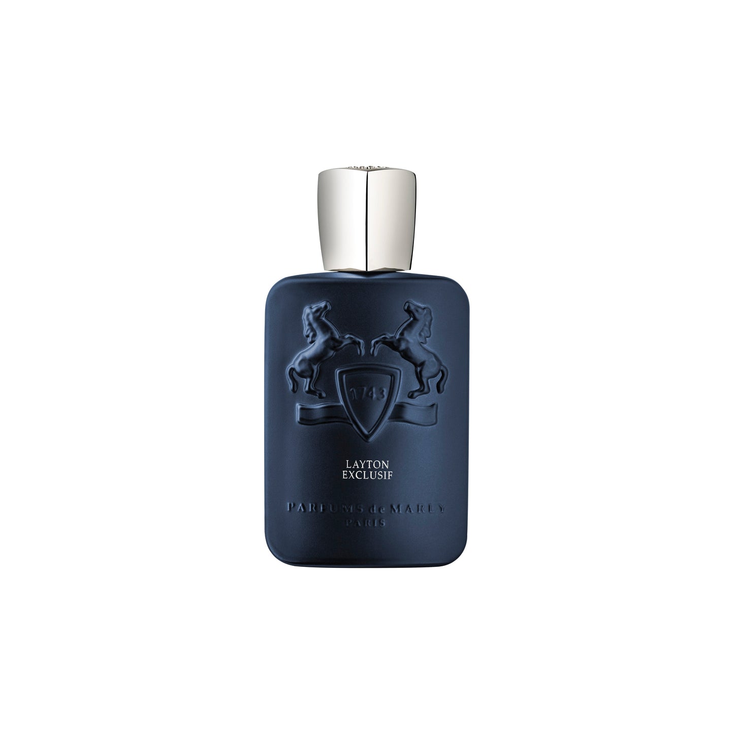 A matte navy blue Layton Exclusive Eau de Parfum bottle by Parfums de Marly, featuring two embossed rearing horses and a shield with a silver cap, stands elegantly against a white background.