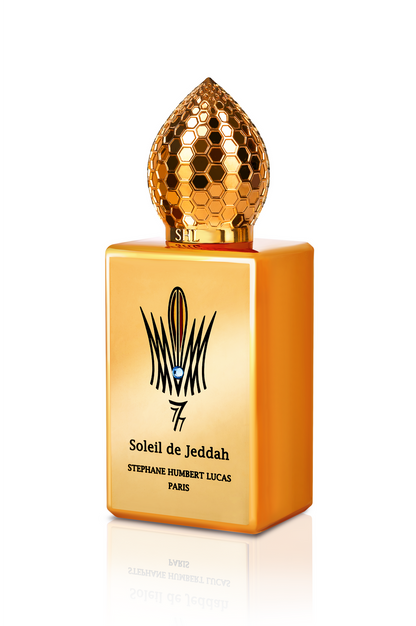 A rectangular, bright orange bottle with a gold dome-shaped cap features the label Soleil de Jeddah Mango Kiss Eau de Parfum by Fragrapedia Haus, adorned with a black emblem for an exquisite gourmand scent.
