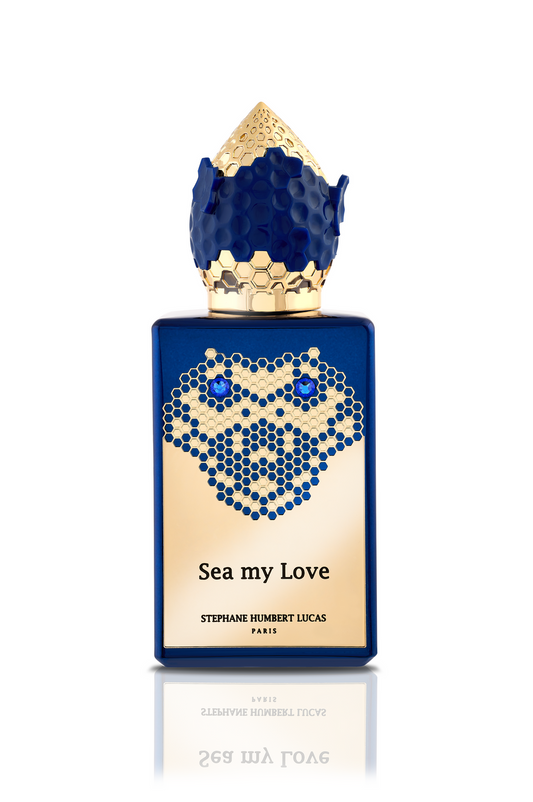 A blue and gold perfume bottle labeled Sea My Love Eau de Parfum by Fragrapedia Haus, featuring a honeycomb pattern and textured gold-tipped cap inspired by ocean legends and the sea’s mysterious depths.