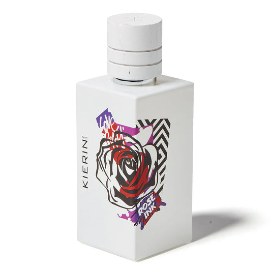 Kierin’s Rose Ink Eau de Parfum comes in a white rectangular bottle adorned with abstract rose and graffiti-style art in black, red, and purple, topped by a white cylindrical cap. This woodsy floral scent is known for its bold unisex appeal.