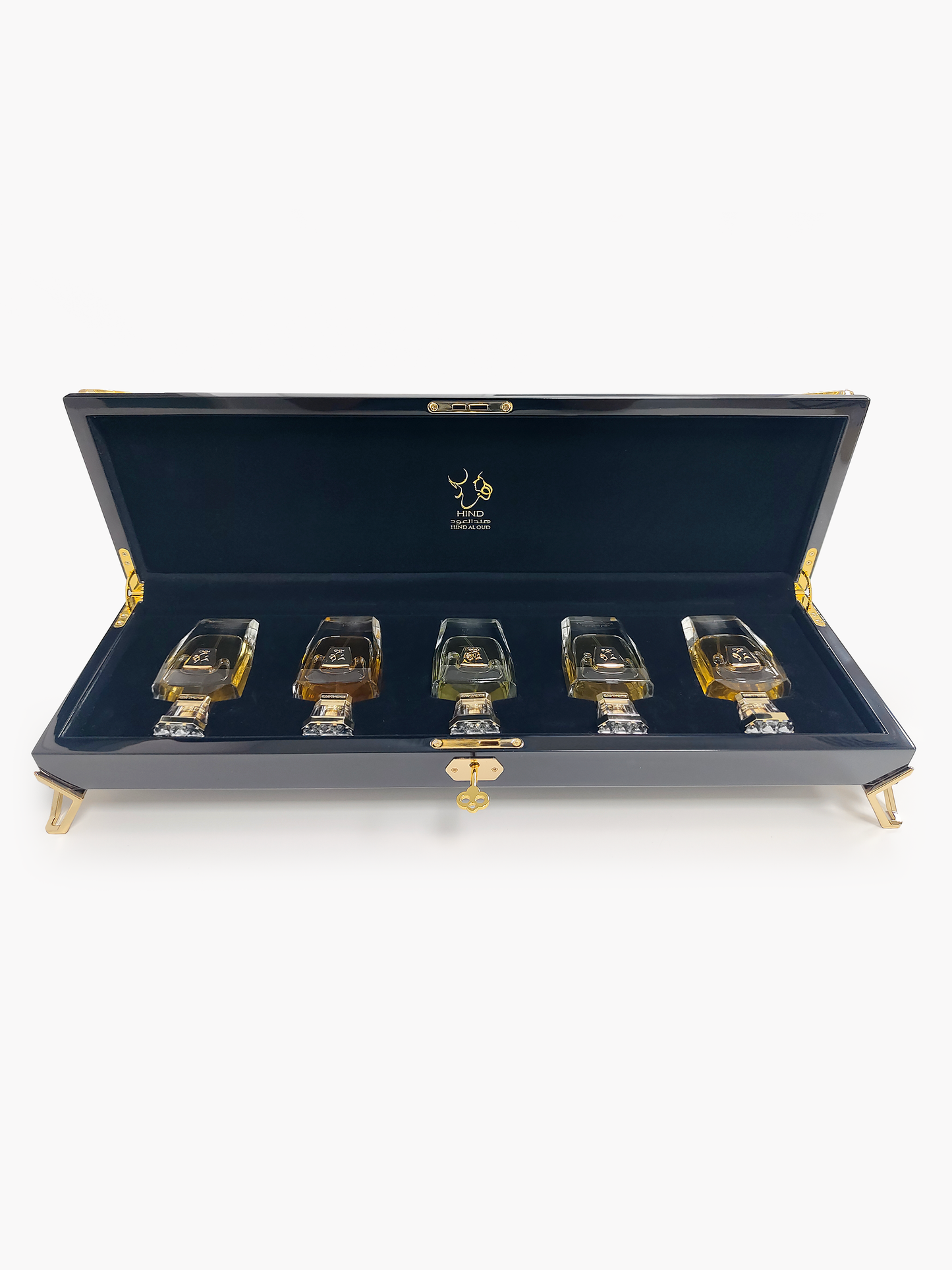 A luxurious black case with gold accents displays the Hind Al Oud Royal Precious Collection—five elegant perfumes arranged on dark blue velvet, making it the perfect gift set from Hind Al Oud.
