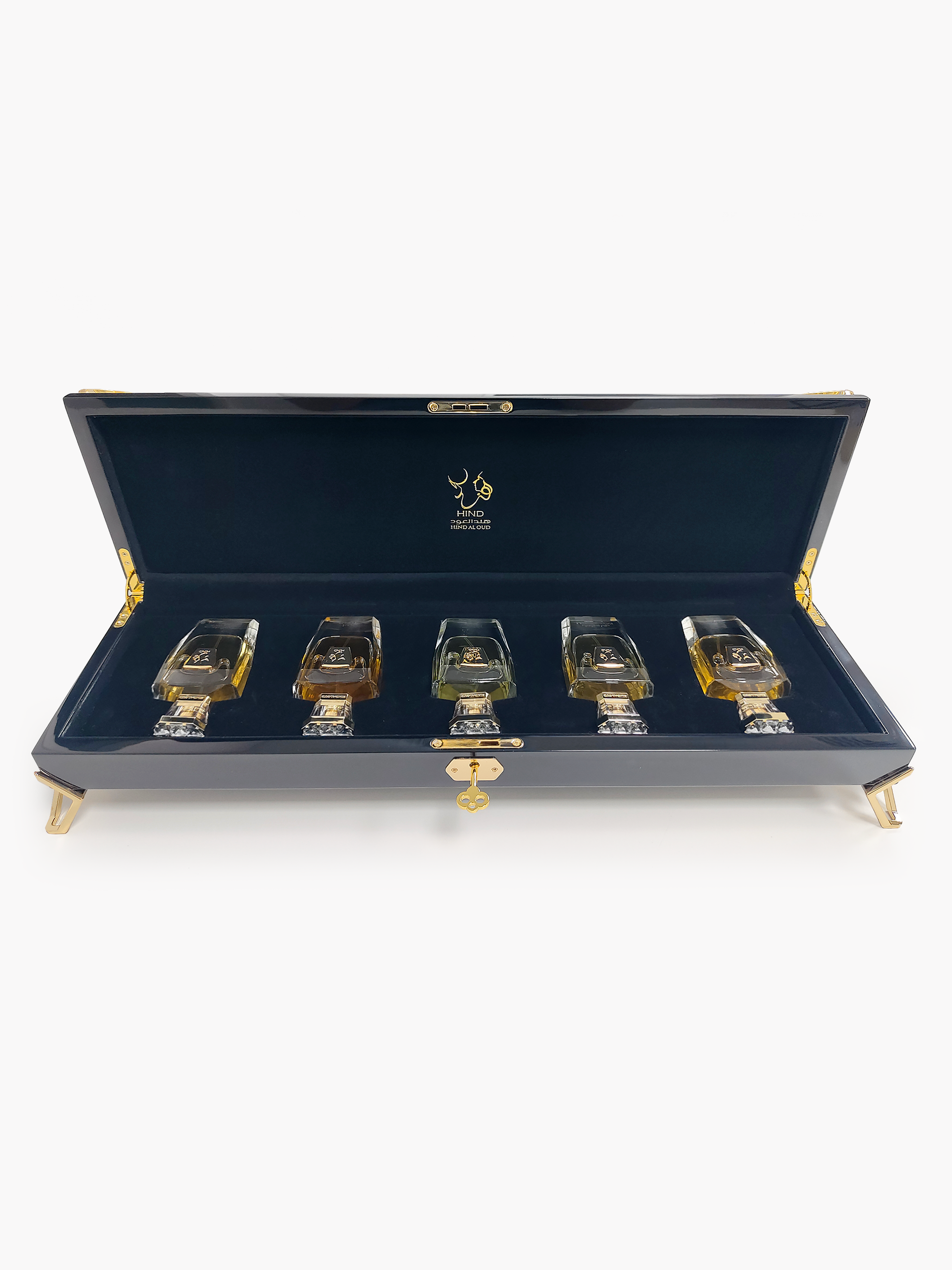 A luxurious black case with gold accents displays the Hind Al Oud Royal Precious Collection—five elegant perfumes arranged on dark blue velvet, making it the perfect gift set from Hind Al Oud.