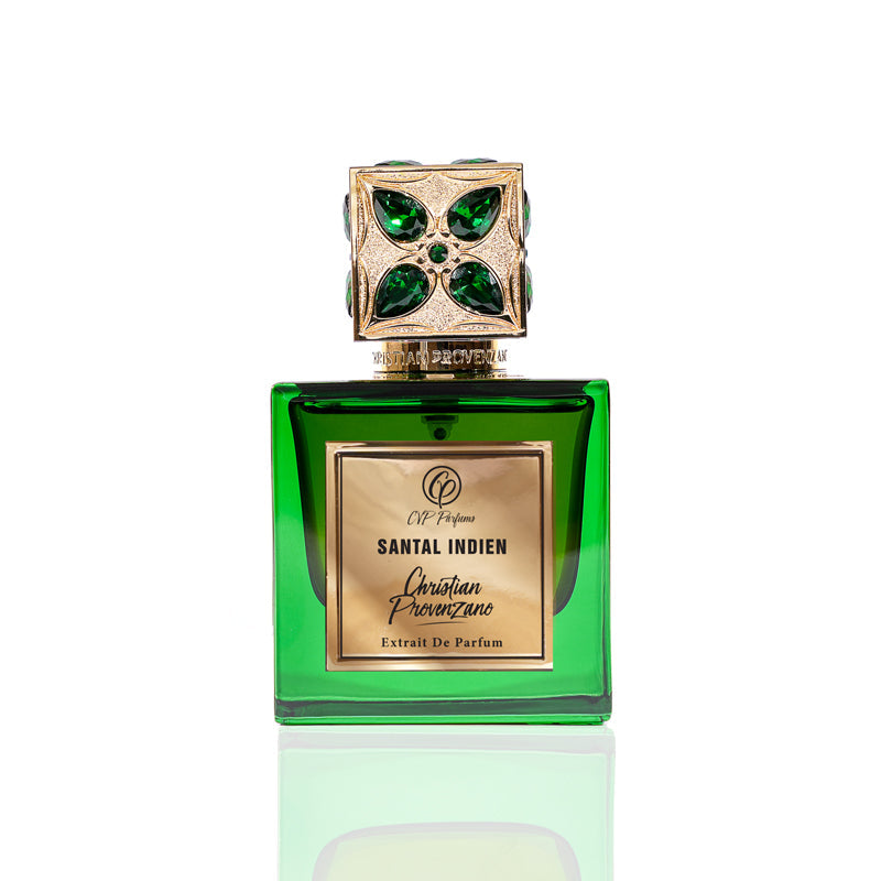 A green glass bottle of Santal Indien Eau de Parfum by Christian Provenzano, topped with a gold cap with green gem accents, captures a luxurious sandalwood scent accented by Tunisian Neroli, set against a white background.