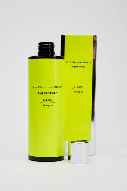A bright yellow SUPERFLUO LAVS SHAMPOO bottle by Filippo Sorcinelli with a black cap and its matching box, both labeled with the product name, stand against a white background. The box features a sleek silver base.