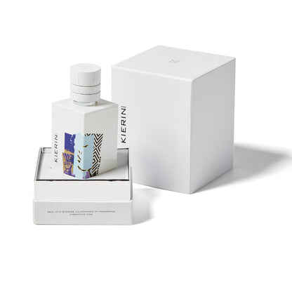 The Kierin Santal Sky Eau de Parfum features a white bottle with colorful abstract art, displayed in an open box with a matching lid and outer box, capturing a rich sandalwood and woody scent.