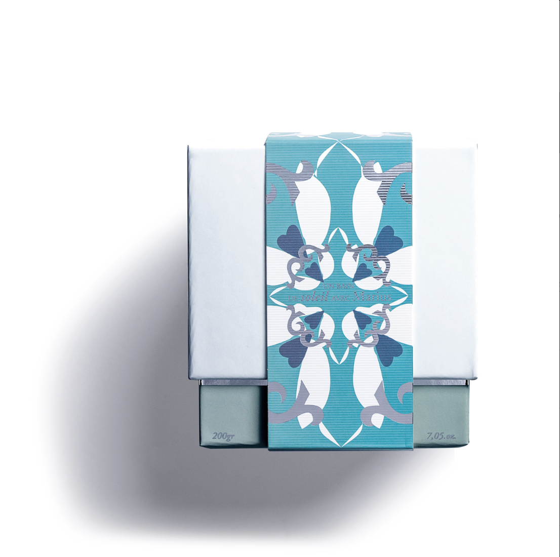 A rectangular white box with a blue patterned band displays "200g / 7.05 oz" and shadows a white background—ideal for presenting the Rose Et Marius BASKING IN THE SUN WITH MARIUS scented candle, handmade in France.