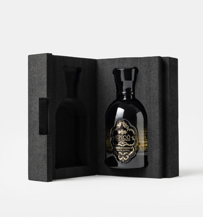 Black bottle with gold label in a black textured box on a white background epico thelycheeus
