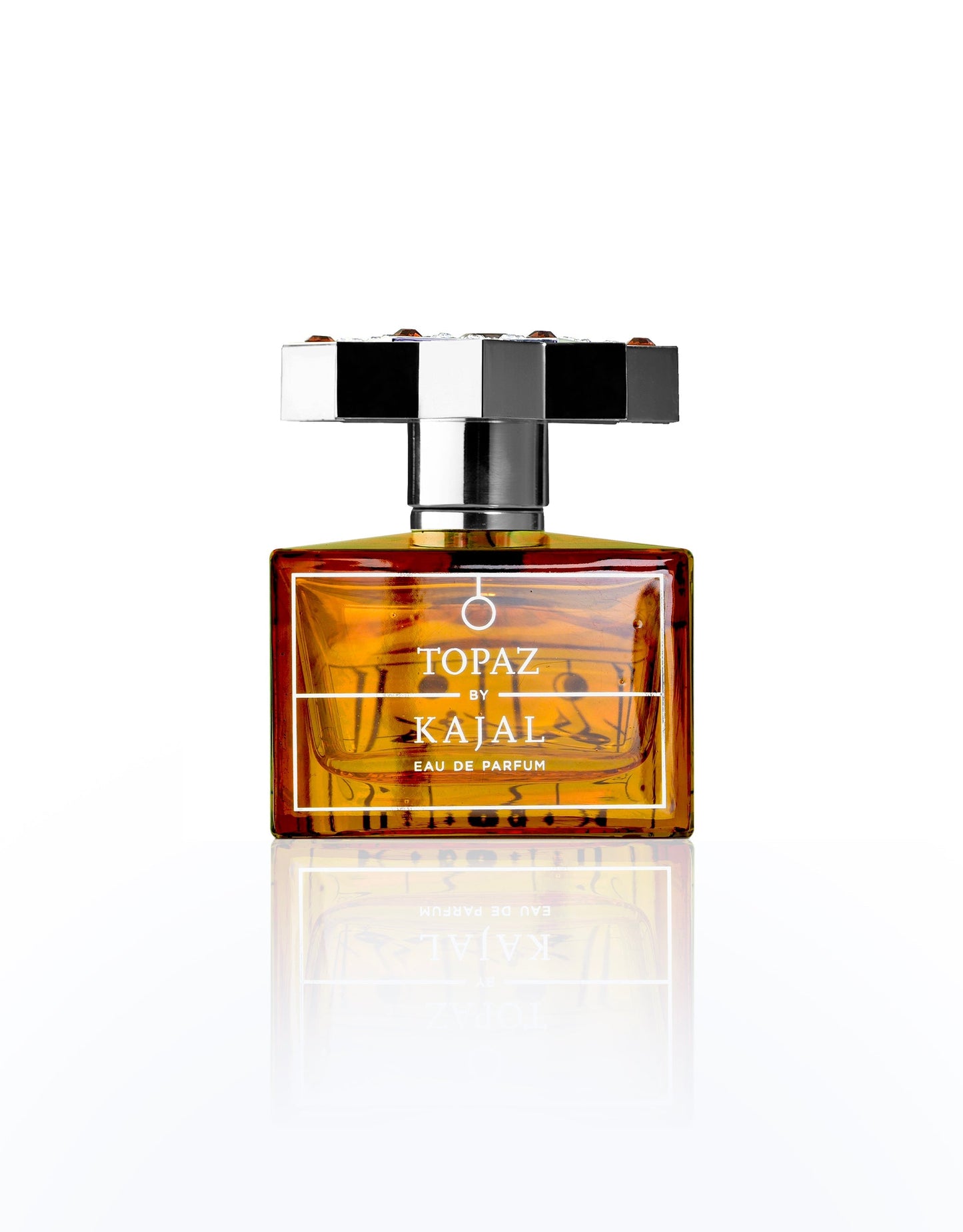 A rectangular amber glass bottle of Topaz Eau de Parfum by Kajal Perfumes Paris, featuring a bold silver and black geometric cap, is displayed against a white background—a symbol of love and passion, like an eternal flame.
