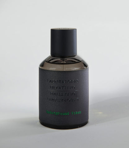 A dark matte bottle labeled Laboratorio Olfattivo holds the Underground Vibes TESTER perfume, with green text at the bottom and a black cylindrical cap, displayed on a light gray surface. Brand: Laboratorio Olfattivo.