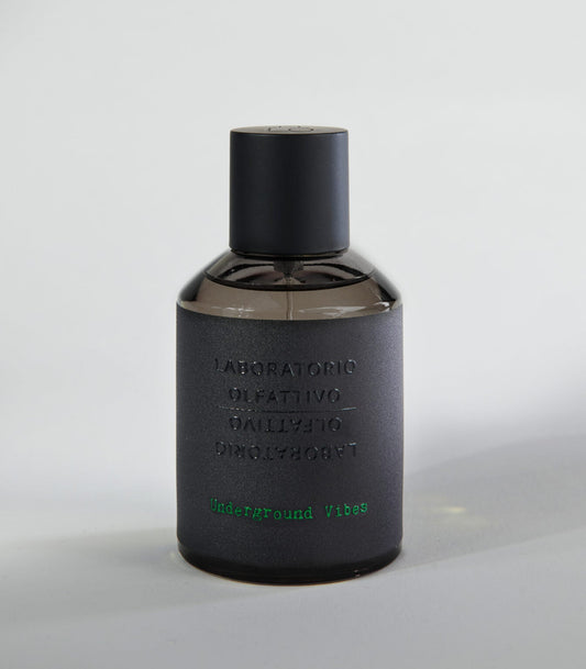 A dark matte bottle labeled Laboratorio Olfattivo holds the Underground Vibes TESTER perfume, with green text at the bottom and a black cylindrical cap, displayed on a light gray surface. Brand: Laboratorio Olfattivo.