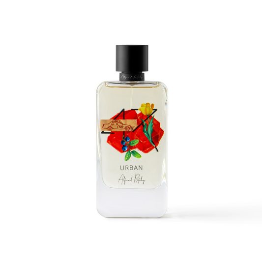 A clear perfume bottle labeled URBAN Eau de Parfum - Alfred Ritchy, with a black cap and colorful abstract art—featuring red shapes, flowers, a yellow detail, and a car—ideal for fans of Alfred Ritchy's Urban men’s fragrance.