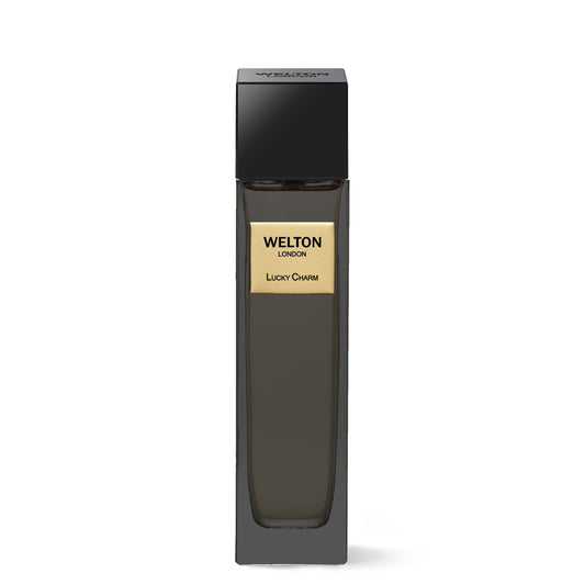 A tall, sleek black bottle with a gold “Lucky Charm EDP” label by Welton and a black square cap stands against a white background—an elegant luxury fragrance for lovers of sophisticated scents.