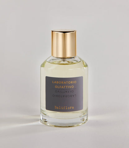 A clear glass bottle of Baliflora - Laboratorio Olfattivo TESTER with a gold cap and gray label, set against a light, neutral background.