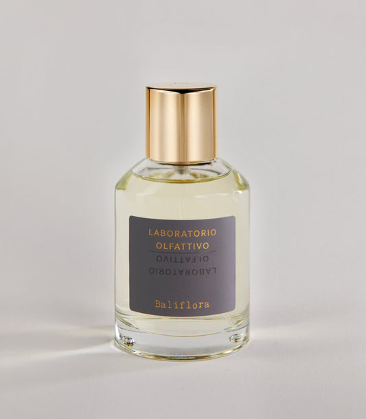 A clear glass bottle of Baliflora - Laboratorio Olfattivo TESTER with a gold cap and gray label, set against a light, neutral background.