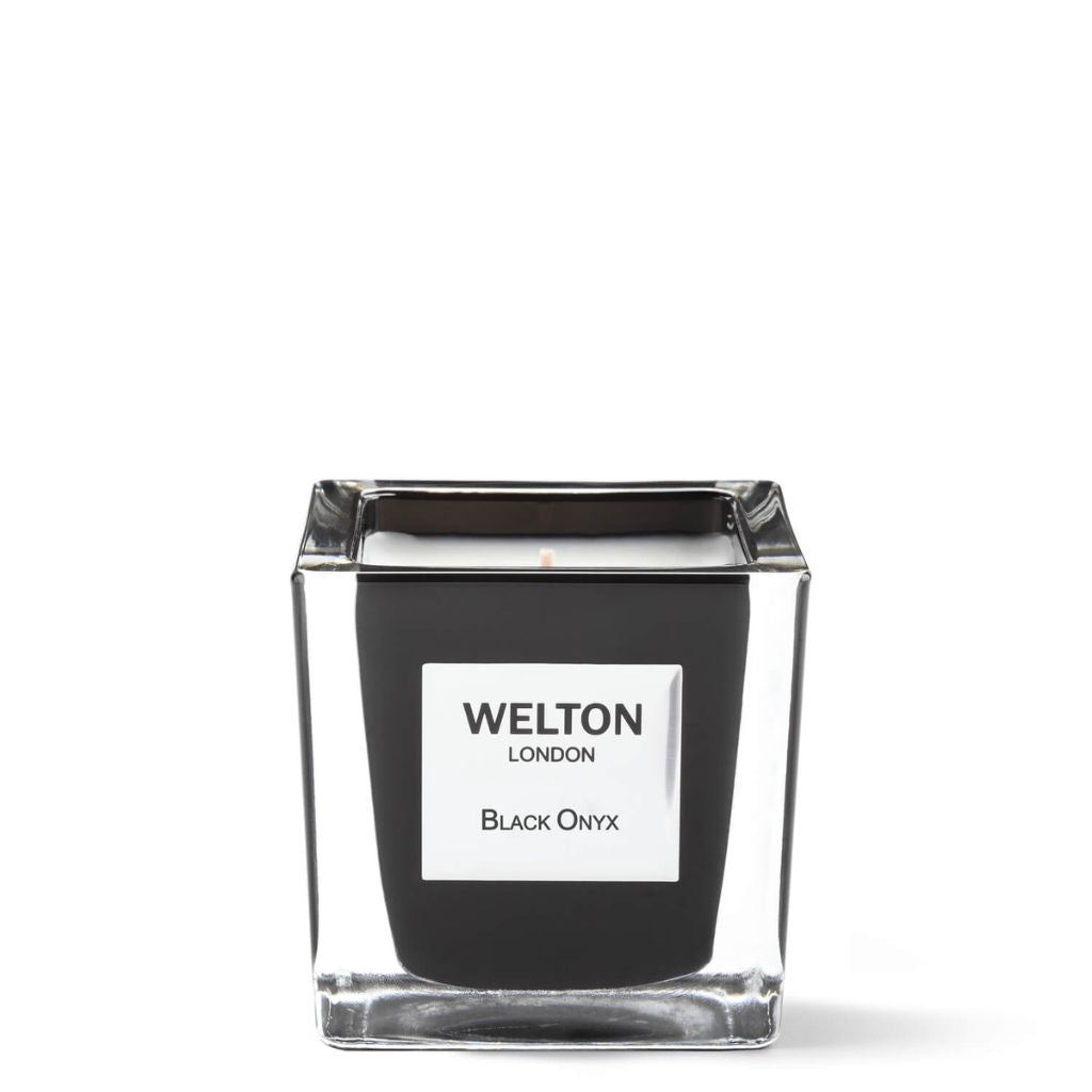 The BLACK ONYX SCENTED CANDLE Classic by Welton London is a luxury candle in a square glass jar with black sides and a white label, offering a woody fragrance, displayed against a plain white background.
