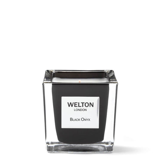 The BLACK ONYX SCENTED CANDLE Classic by Welton London is a luxury candle in a square glass jar with black sides and a white label, offering a woody fragrance, displayed against a plain white background.