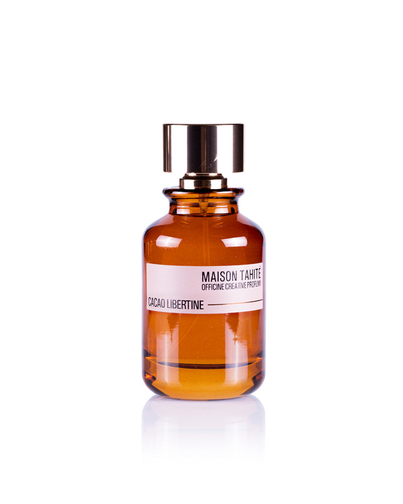 A brown glass bottle with a gold cap, labeled Maison Tahite Cacao Libertine Eau de Parfum, offers a gourmand scent ideal for vanilla and patchouli perfume lovers, shown against a white background.