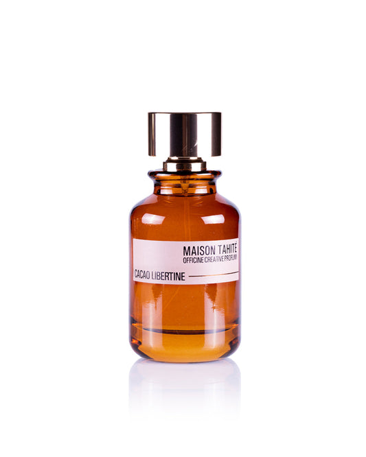A brown glass bottle with a gold cap, labeled Maison Tahite Cacao Libertine Eau de Parfum, offers a gourmand scent ideal for vanilla and patchouli perfume lovers, shown against a white background.
