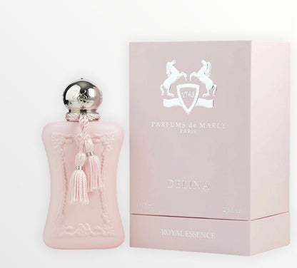 A pink bottle of Delina Eau de Parfum by Parfums de Marly, topped with a silver cap and tassel, stands beside a matching pink box featuring the brand’s white two-horse logo. This floral fragrance beautifully captures femininity.