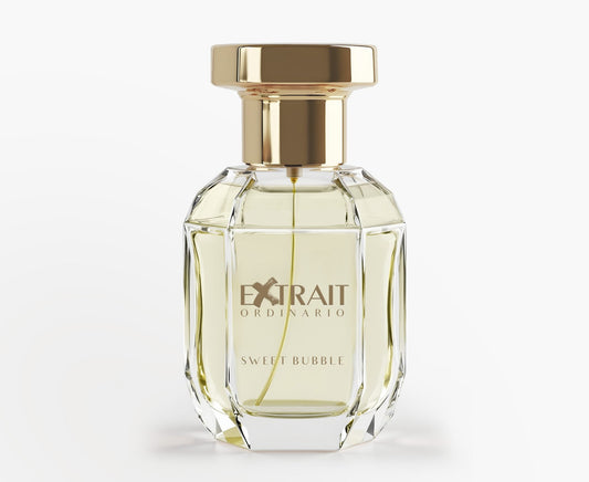 A clear, faceted glass bottle with a gold cap and 'Extrait Ordinario Sweet Bubble' label holds pale yellow Sweet Bubble - Extrait Ordinario perfume, a playful fruity floral scent from Extrait Ordinario, shown on a plain white background.