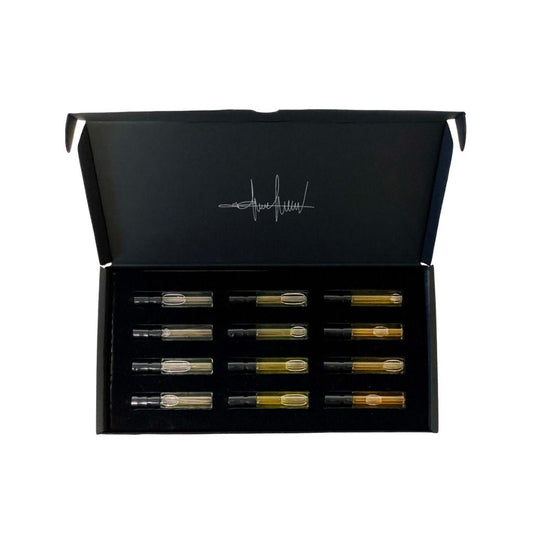 The Filippo Sorcinelli Discovery Kit features 12 perfumes from the Unum and Extrait De Musique Collections in glass vials, arranged in a black box with a hinged lid and a white signature logo inside.