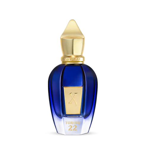 A blue glass perfume bottle with a gold cap and label embossed with TORINO22 on the front, inspired by professional tennis, from Fragrapedia Haus. Product: Torino 22 Eau de Parfum - Xerjoff. Set against a plain white background.