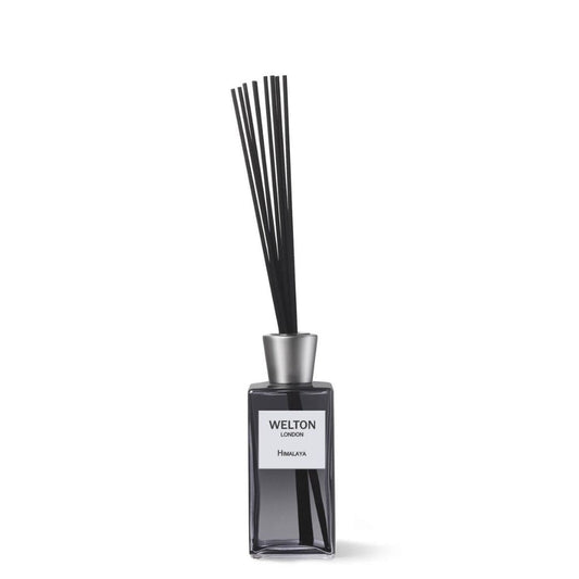 The Welton London HIMALAYA HOME FRAGRANCE DIFFUSER features a rectangular glass bottle with a silver cap and black reed sticks, offering a refreshing citrus tea aroma and subtle jasmine floral notes, set against a plain white background.