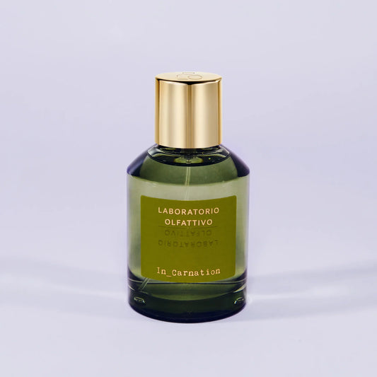 'In_Carnation Laboratorio Olfattivo'Green perfume bottle with gold cap on a light gray background
