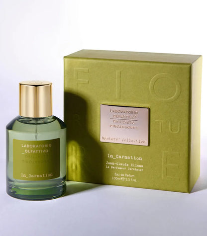 Perfume bottle and packaging with ''In_Carnation Laboratorio Olfattivo'' branding on a light background