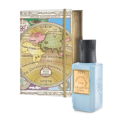 A blue LA DANZA DELLE LIBELLULE EXCEPTIONAL EDITION EXTRAIT bottle by Nobile 1942, with a gold label and black cap, stands before a decorative box featuring a vintage world map labeled Special Edition Extrait.