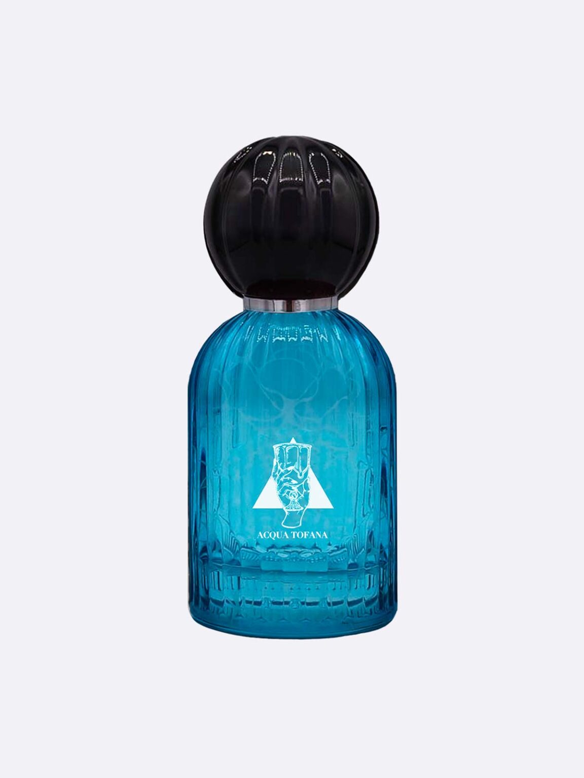 A blue glass perfume bottle with a large round black cap. The front shows a white emblem and “Acqua Tofana - Les Folies du Parfum” by Les Folies du Parfum, evoking a seductive scent. The background is plain and light-colored.