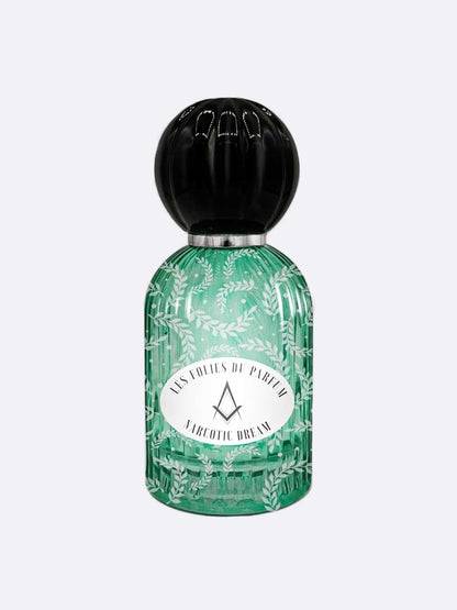A green glass bottle with leaf patterns, a round black cap, and a label reading LES FOLIES DU PARFUM and NARCOTIC DREAM holds this enchanting perfume blending fig and licorice by Les Folies du Parfum.