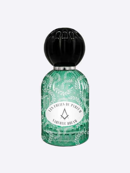 A green glass bottle with leaf patterns, a round black cap, and a label reading LES FOLIES DU PARFUM and NARCOTIC DREAM holds this enchanting perfume blending fig and licorice by Les Folies du Parfum.
