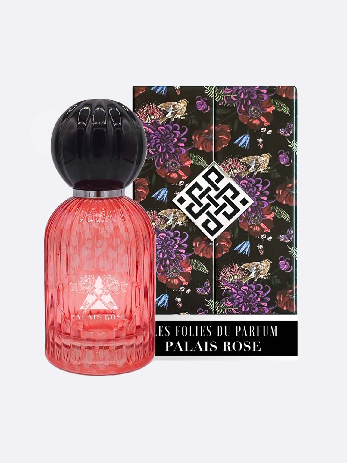 A pink ribbed glass perfume bottle with a black cap stands before a floral box displaying the white Les Folies du Parfum logo and "Palais Rose - Les Folies du Parfum," capturing the scent’s elegant allure.