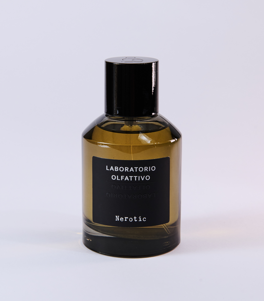 A green glass bottle of Nerotic Eau de Parfum by Laboratorio Olfattivo, with a black cap and label, sits on a white background. This unisex fragrance features masculine notes.