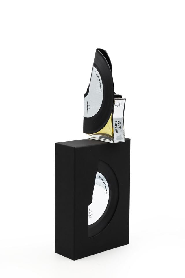 'Filippo Sorcinelli Organ #2'Black rectangular box with a glass container holding a small bottle of perfume on a white background