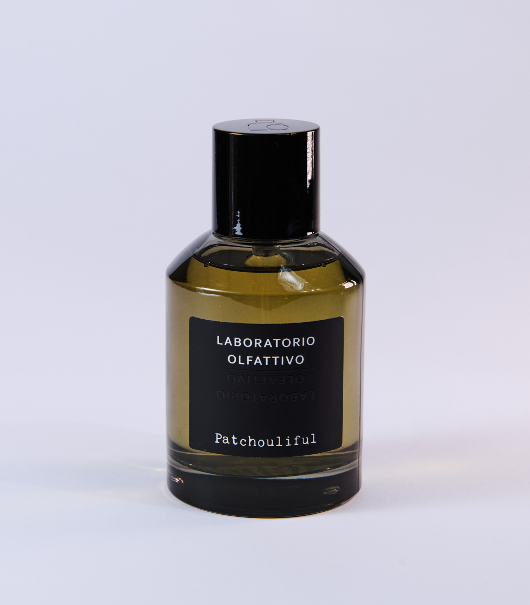 The Patchouliful - Laboratorio Olfattivo perfume by Laboratorio Olfattivo features a black-capped glass bottle and amber liquid, embodying the regal patchouli character of this fragrance against a light background.