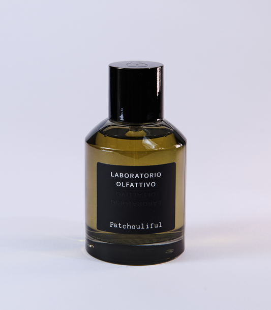 The Patchouliful - Laboratorio Olfattivo perfume by Laboratorio Olfattivo features a black-capped glass bottle and amber liquid, embodying the regal patchouli character of this fragrance against a light background.